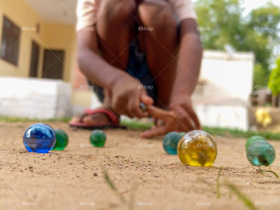 a child playing Goti.......