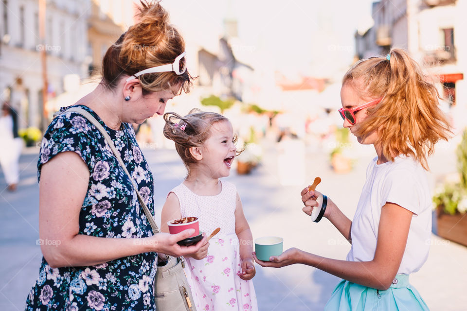 Family spending time together in the city centre eating ice cream on a summer day