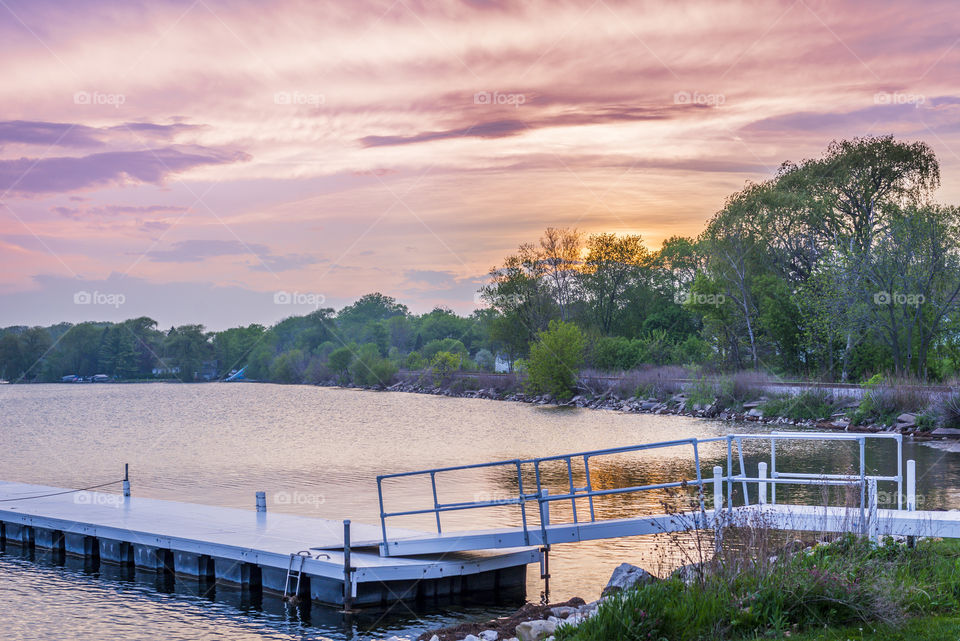 Empty pier on Pewaukee Lake at sunset. White pier on lake in Pewaukee WI 