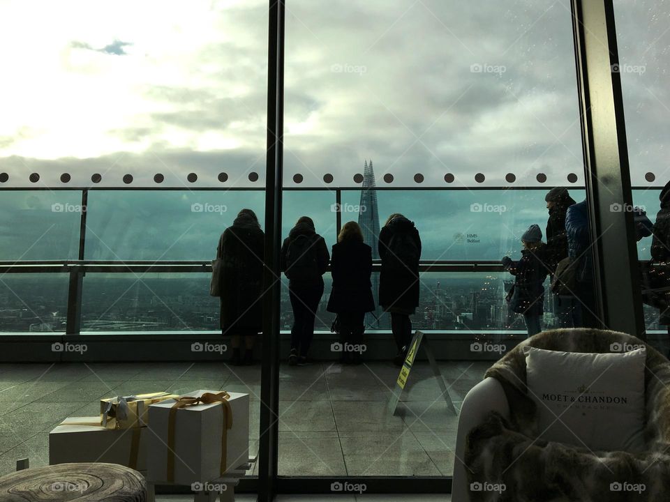 Photo taken from inside The Sky Garden of people outside on the balcony looking at The Shard and views over London 🇬🇧 