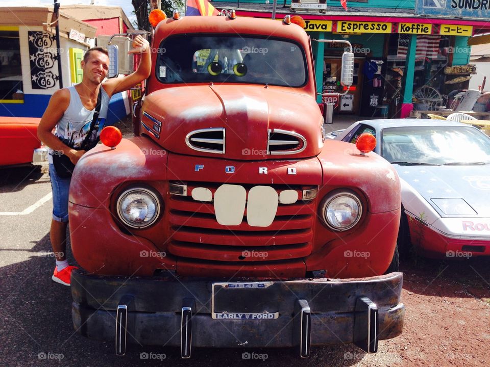 Man gesturing thumbs down sign standing near vintage car