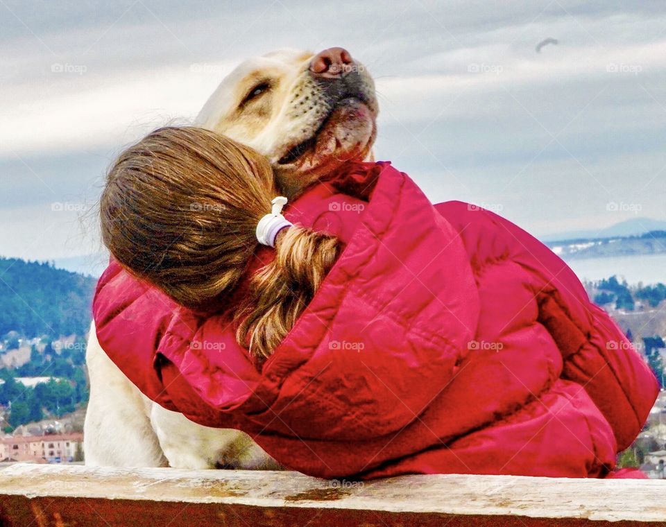 Dog hugs are the best hugs - Labrador and girl embrace 