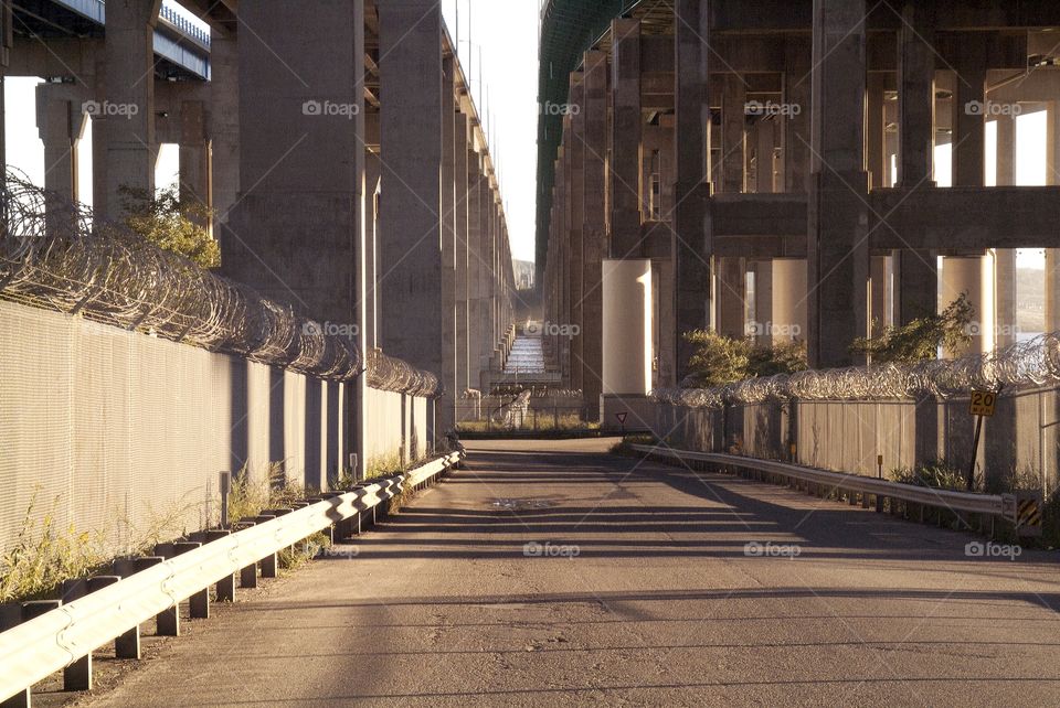 Barb wired fence and concrete pillars make up this highway city down below.