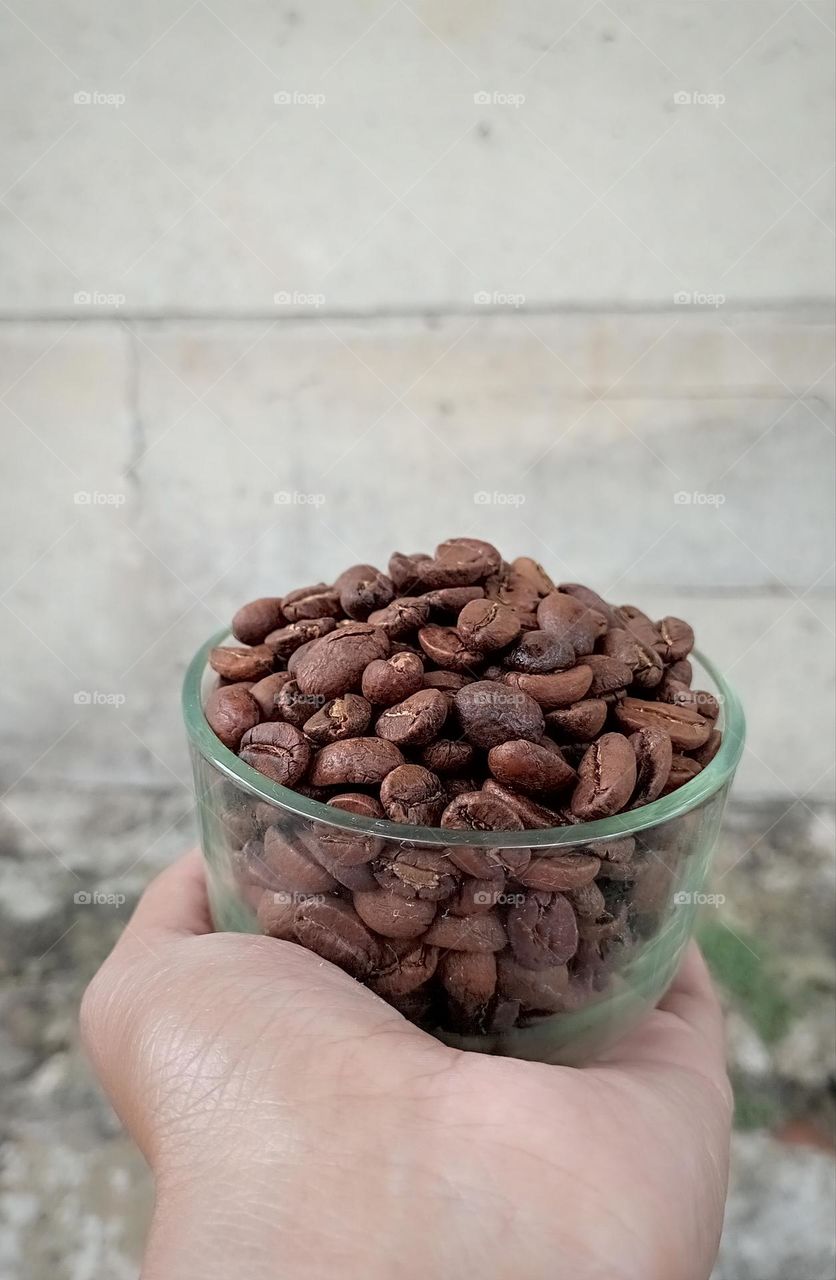 A cup of coffee beans in a hand