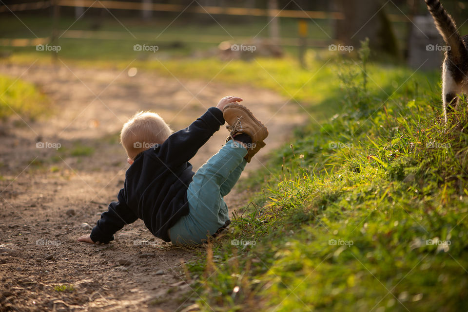 Baby boy and cat playing outdoor