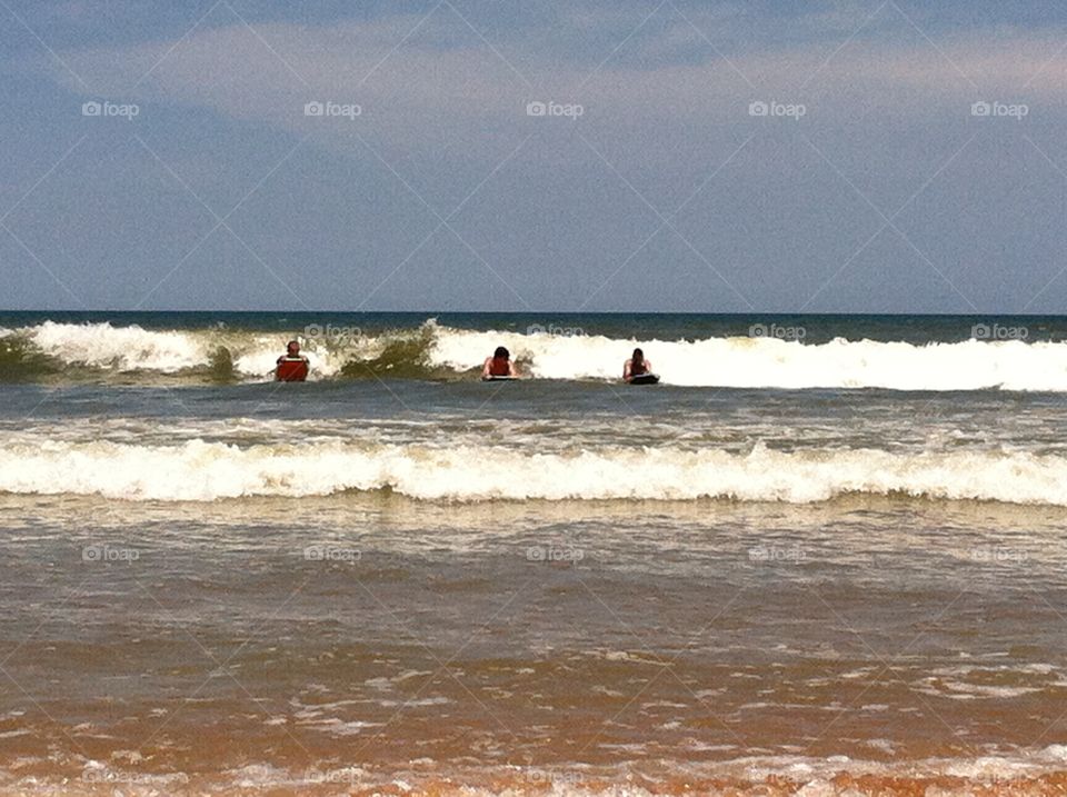 Boys boogie boarding . The boys out in the waves 