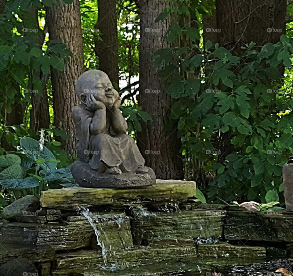 Buddha statue by waterfall