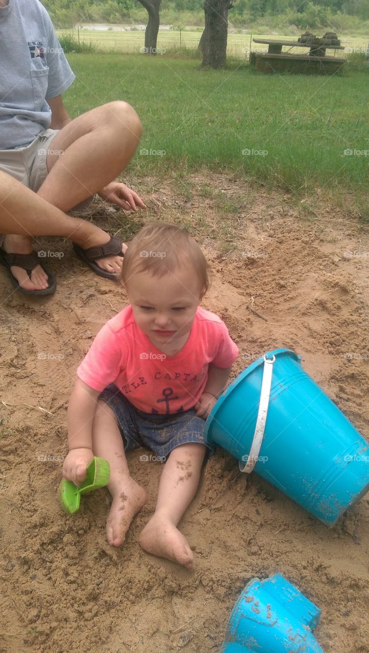 Little boy playing in sand.