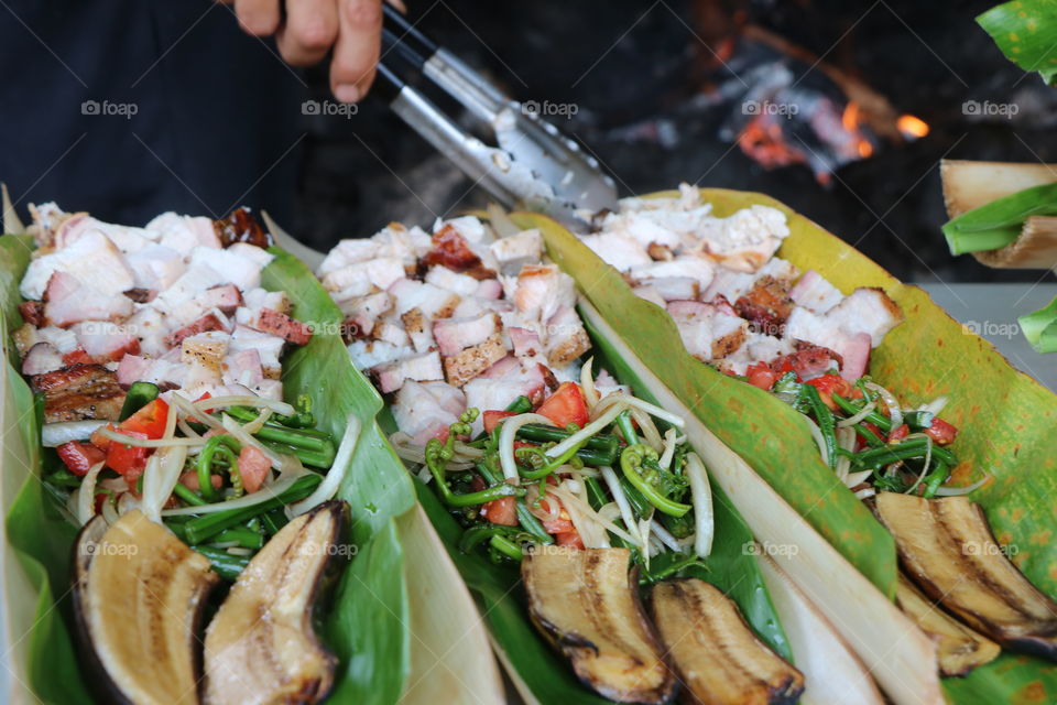 Barbecue pork , chicken and bananas nicely arranged on a bamboo plater 