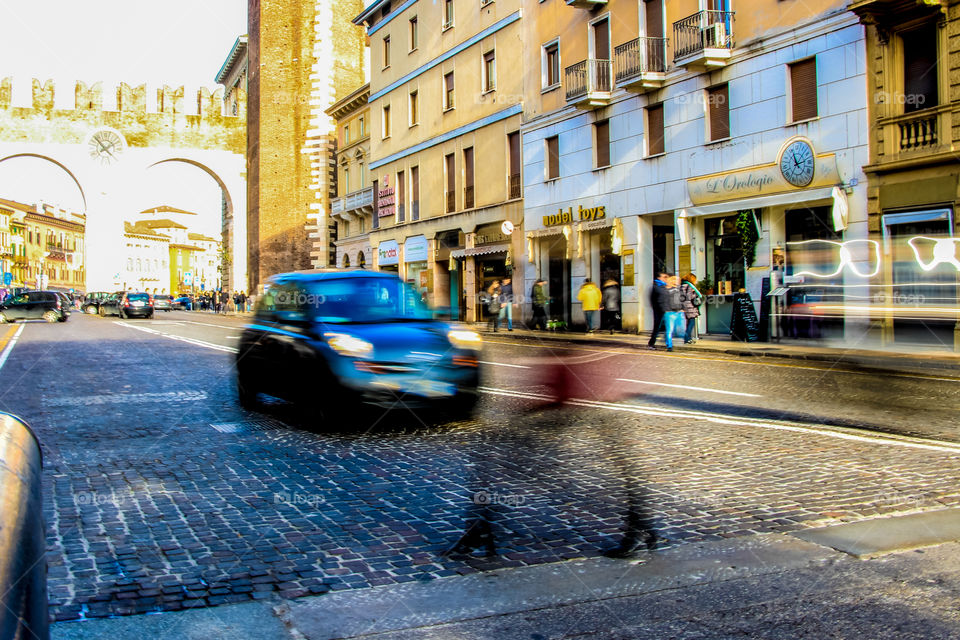A woman passing the street in the city of Verona