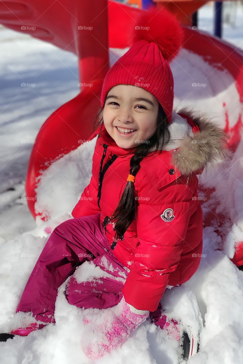 little girl in the park in the spring on the slide