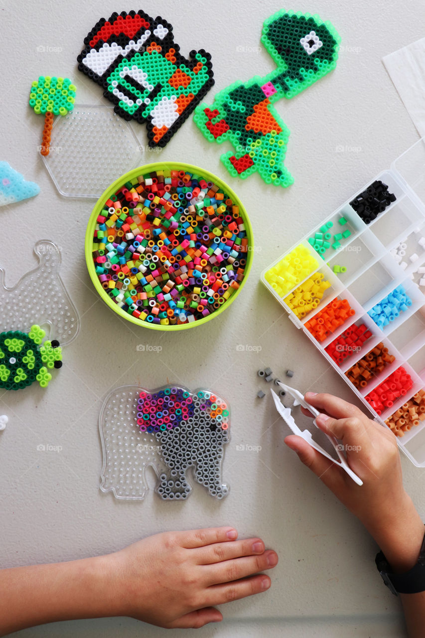 Child creating art with beads