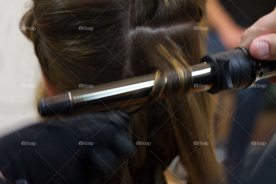 Hairdresser making hairstyle to woman