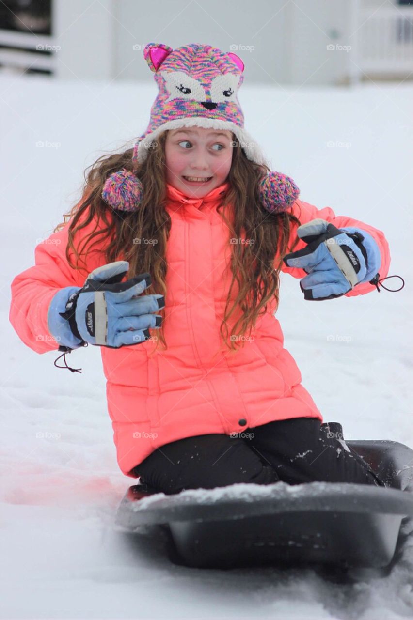 Girl riding on sled during winter