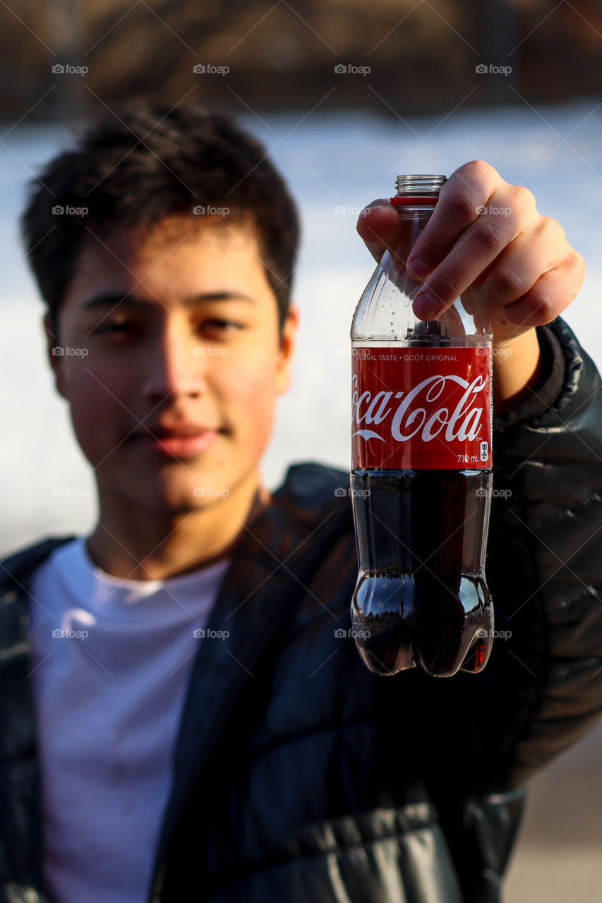 Young handsome man with a bottle of Coca-Cola