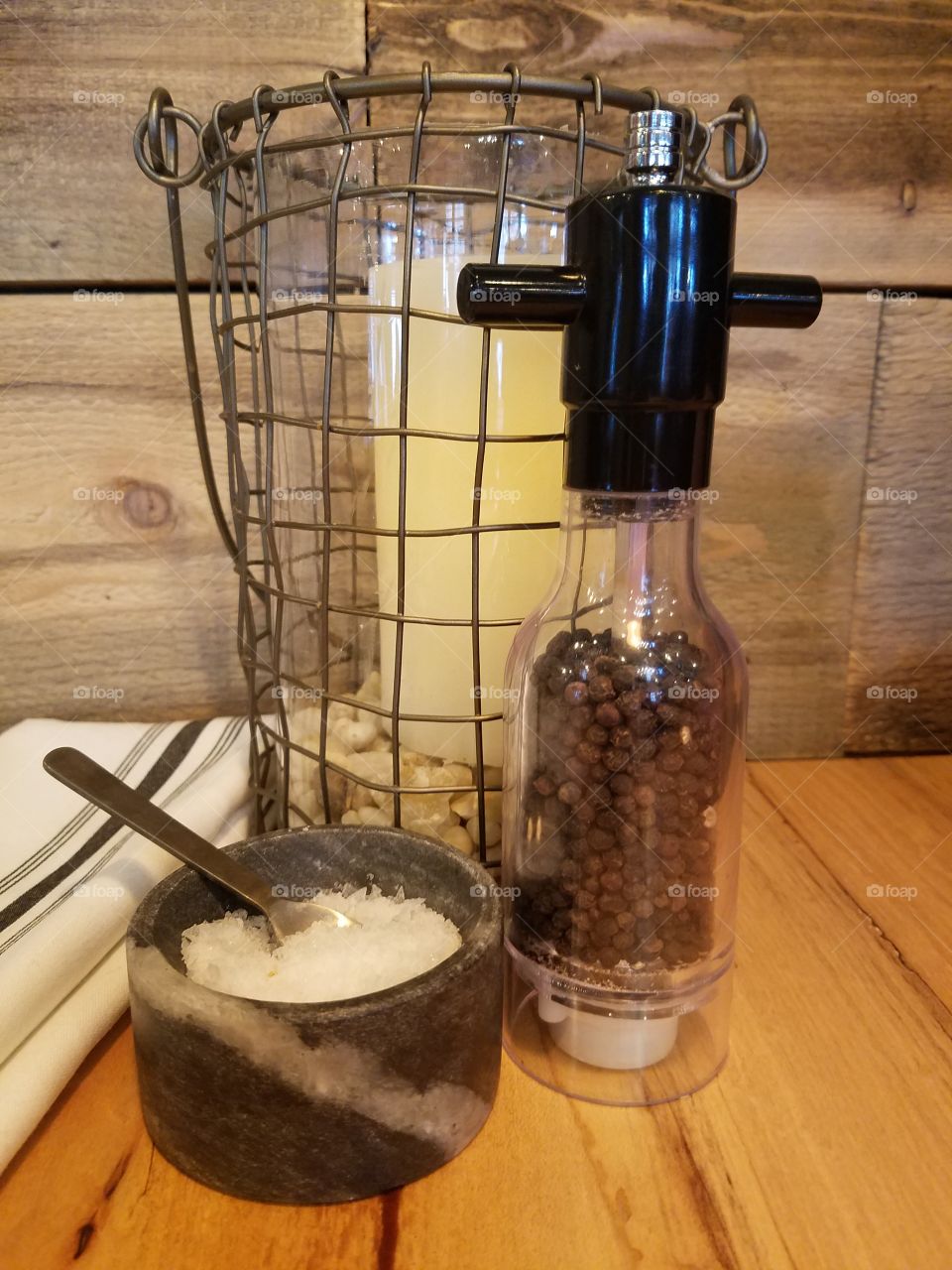 Fresh salt and pepper on a table with a cloth napkin and decor