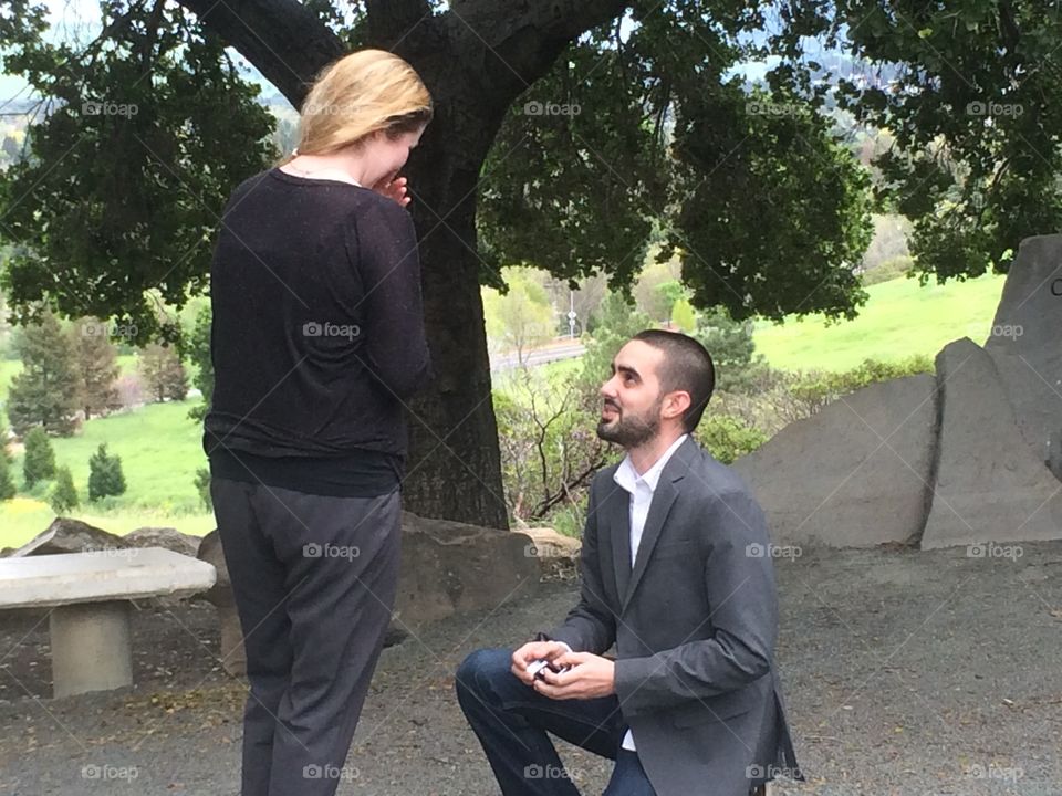 Man down on his knee proposing to woman