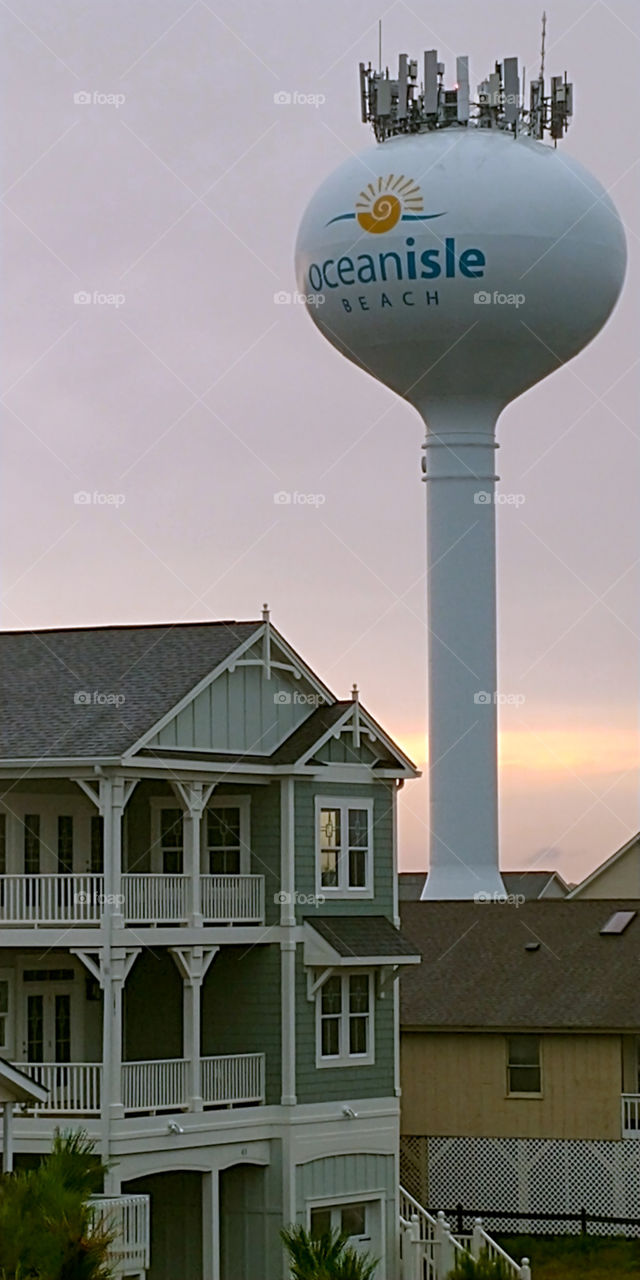 Water Tower and housing on NC beach with sunset behind.