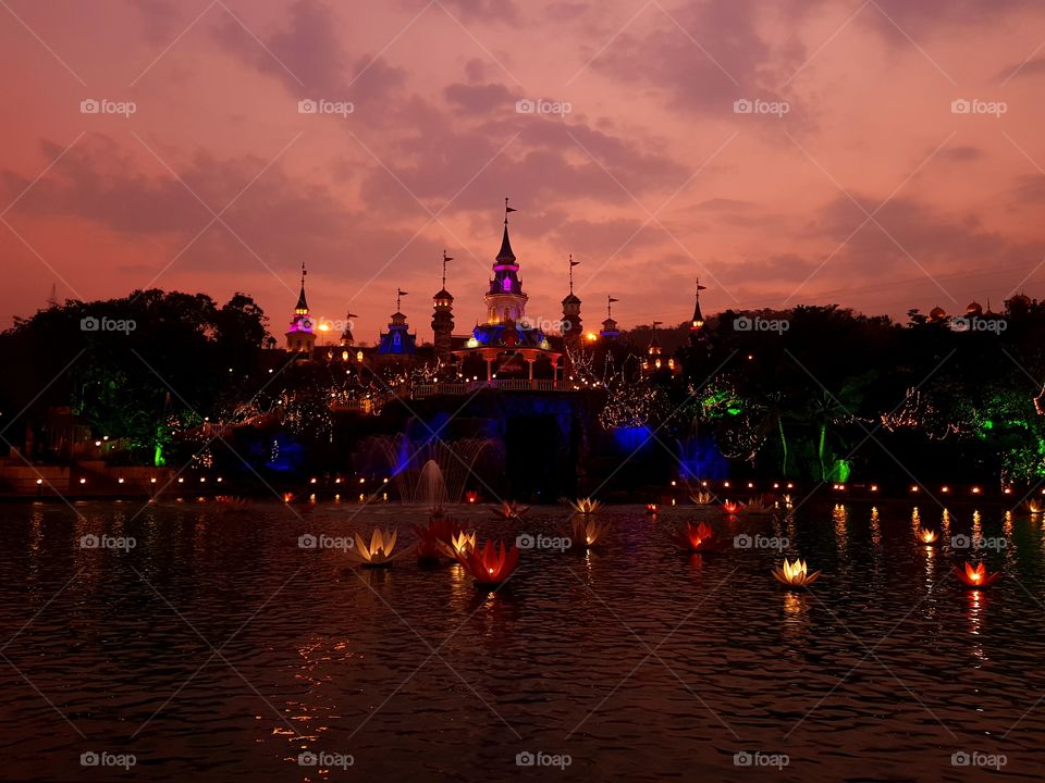 Imagica Theme Park. Beautiful castle down the setting sun surrounded by water.