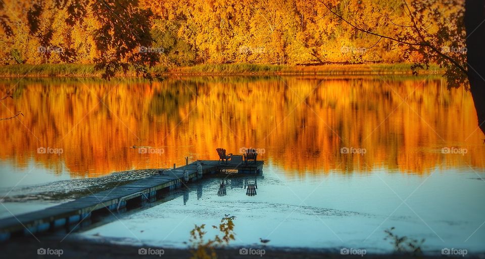 Reflection of pier and autumn trees