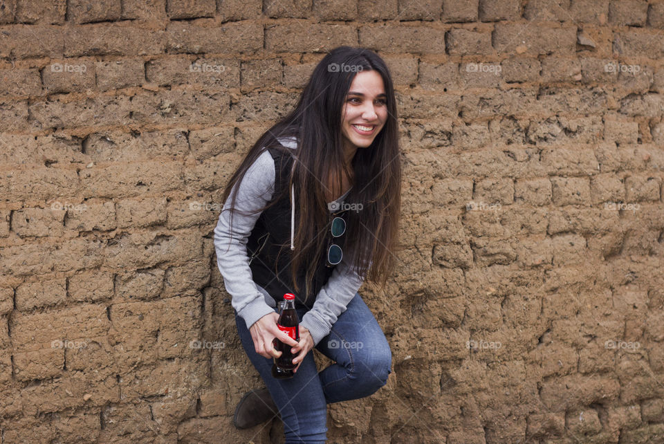 Young woman holds Coca-Cola bottle