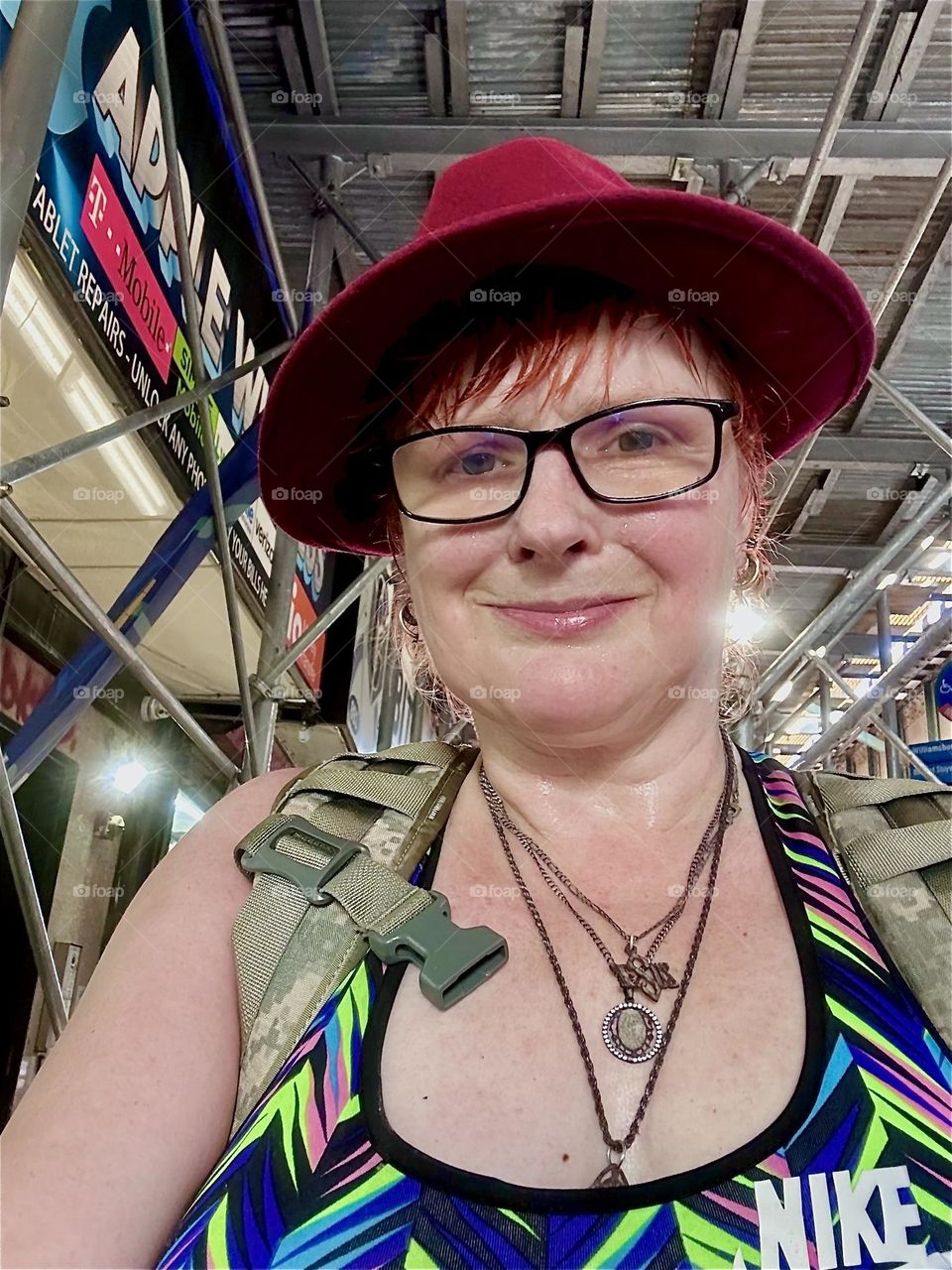 I, “Petra Schiller” a.k.a. “Maxine Firefox” a.k.a. “Maximiliane Feuerfuchs” am in “Bushwick”, Bklyn, corner of “Jefferson St”, “B’way” and “Myrtle Ave” at the “Myrtle Ave” “M” train station overpass w many stores beneath. 2024. Hypnotic Productions