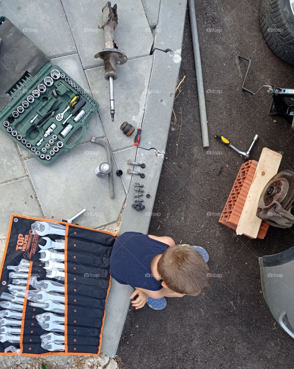 Let's fix this! A kid, tools and a broken wheel.