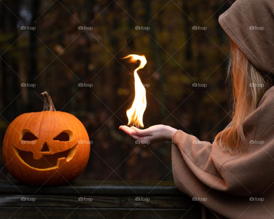 Flame magic; flame pointing from a woman’s hand towards an evil pumpkin 