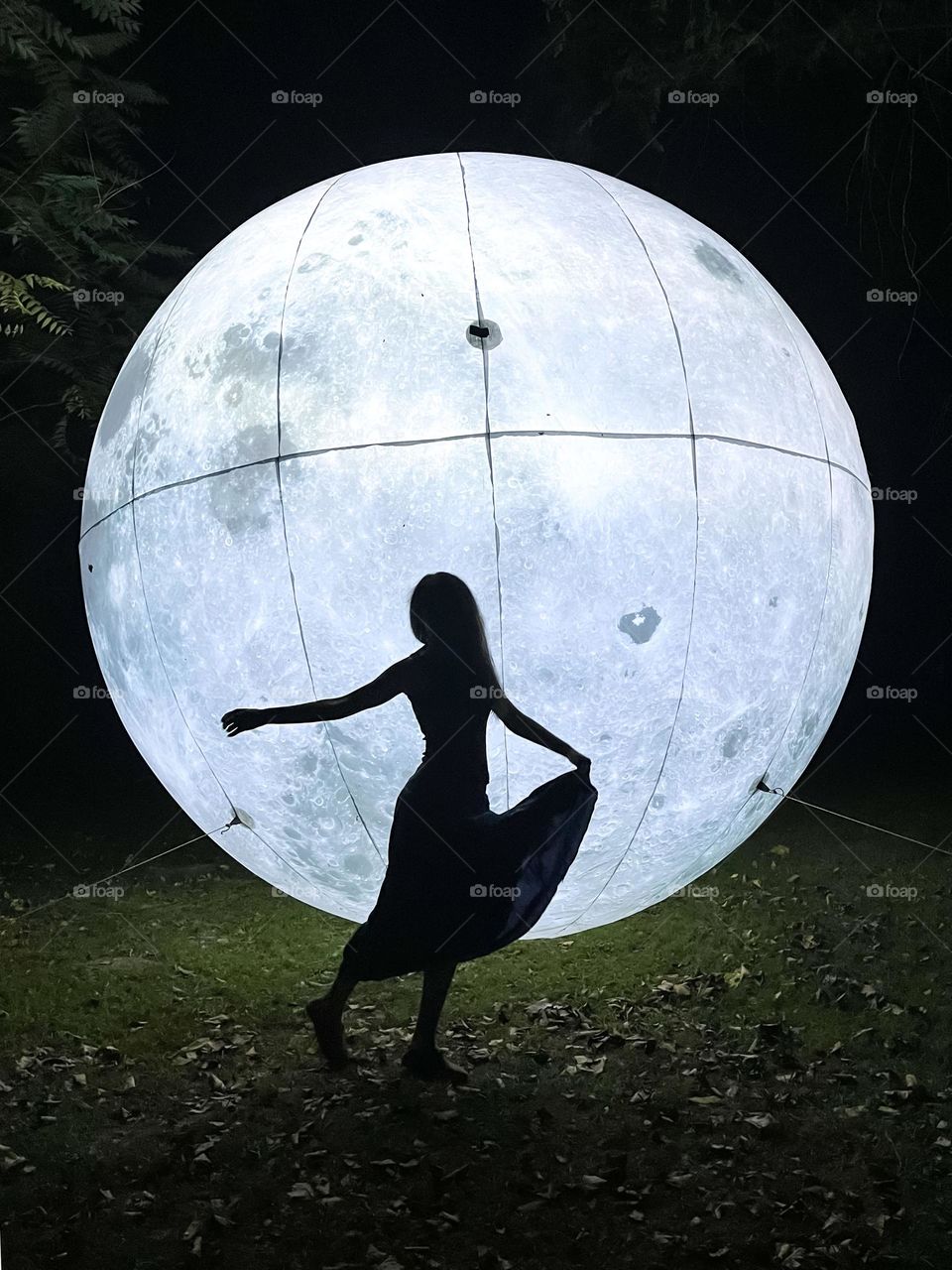 Woman Dances on Front of Art Installation Moon