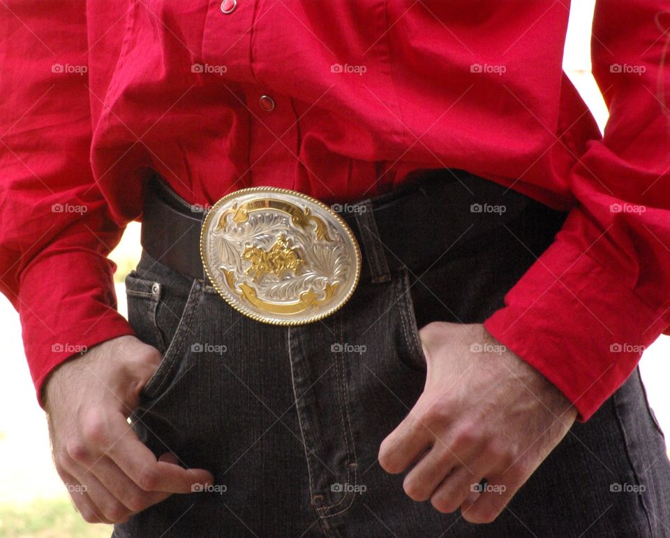 Mid section of cowboy hands in pockets