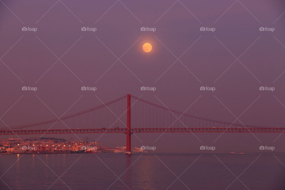 moonrise in Lisbon over the bridge and ocean