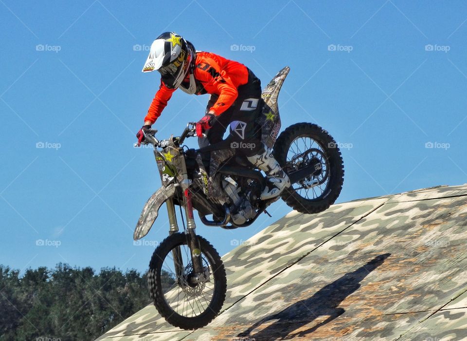 Motorcycle Stunt Riding. Motorcycle Rider Performing Ramp Tricks
