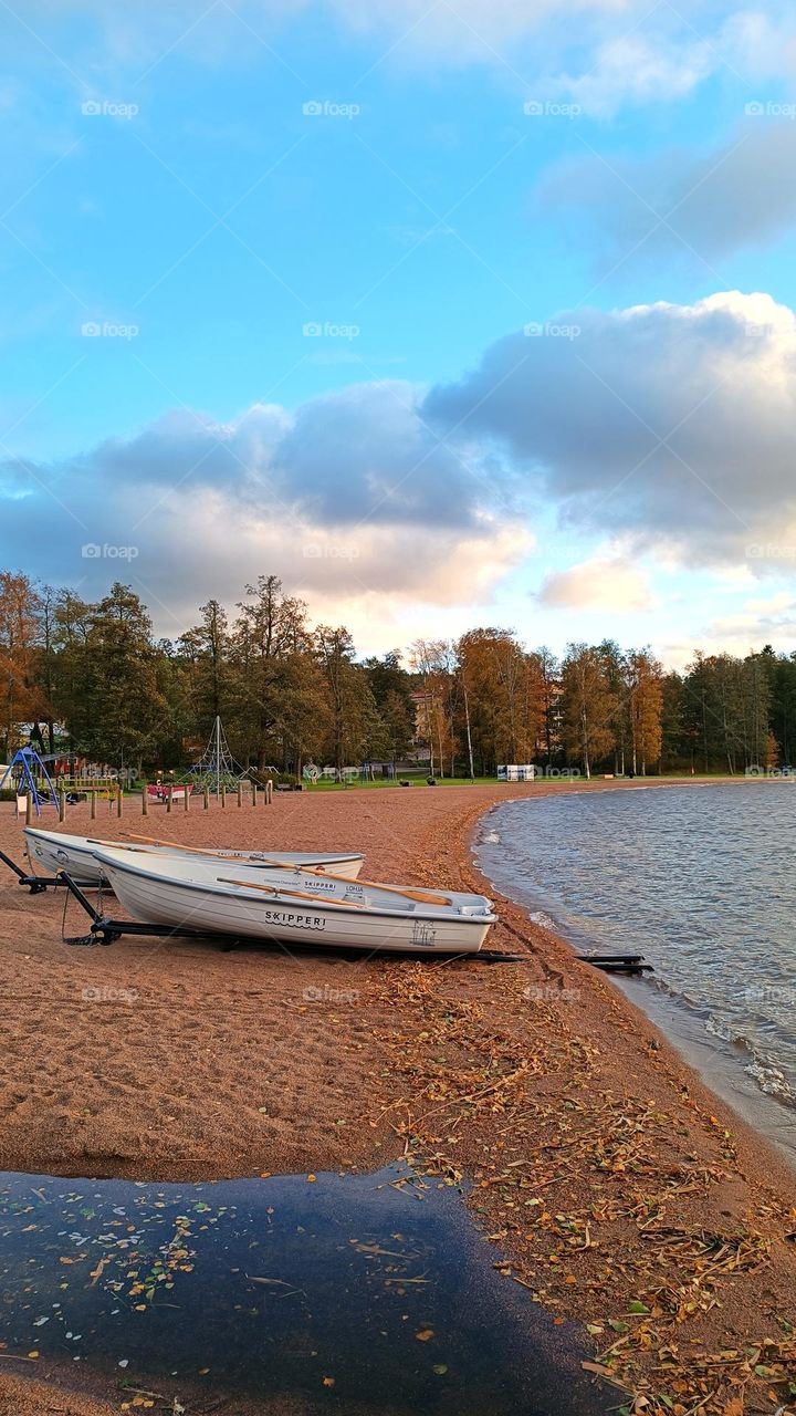 Boats on the lake shore in autumn, deserted beach