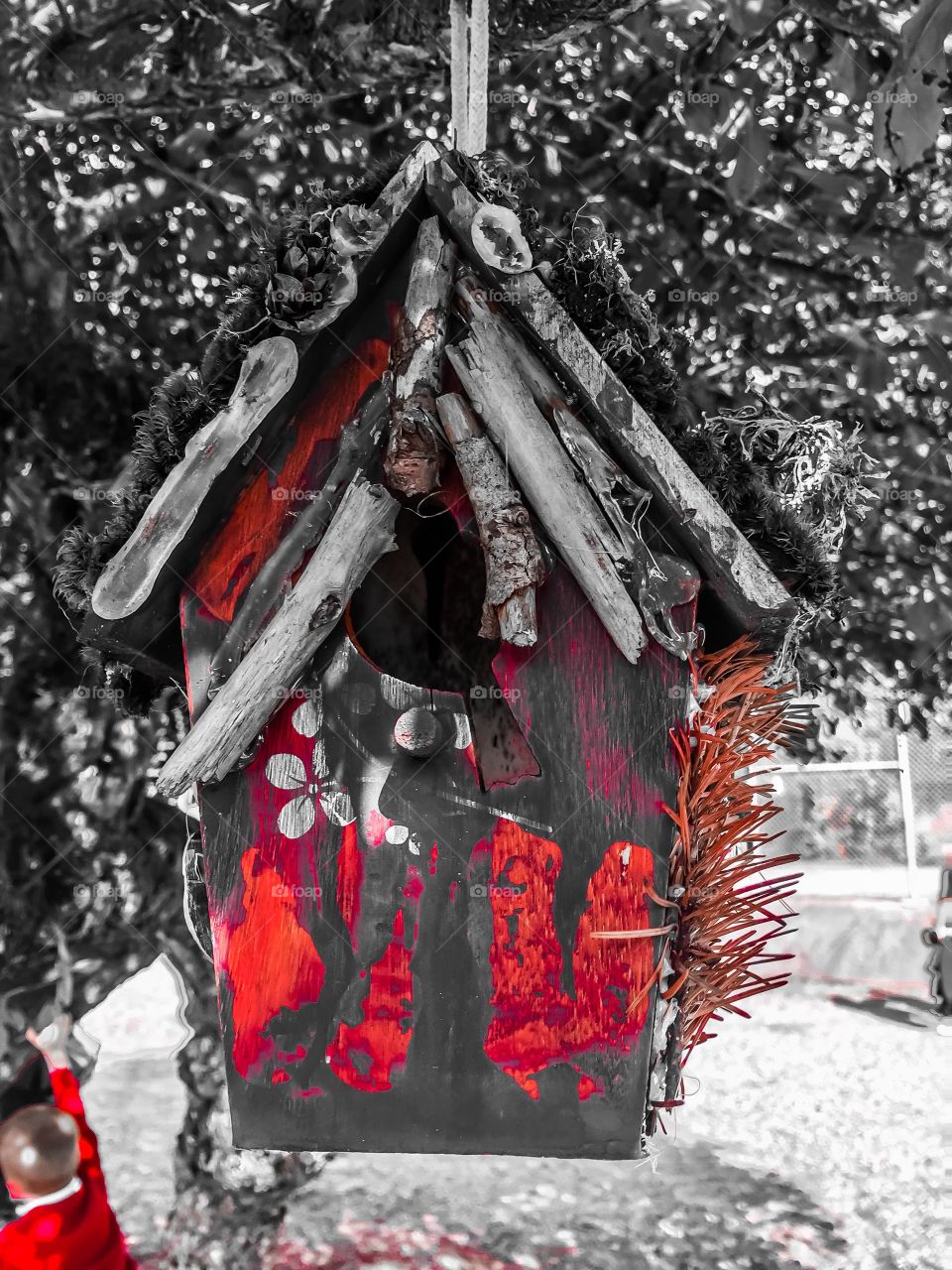 Red accents on a black/white background of a beautiful birdhouse in a local schoolyard