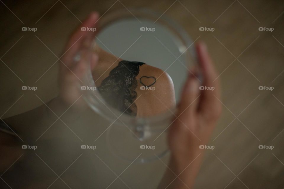 reflection of a beautiful part of the girl's body in the mirror, the mirror is round, small, beautiful lips and shades of photography