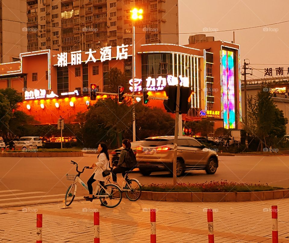 Two ladies wait patiently to cross a highway in east Changsha, China.