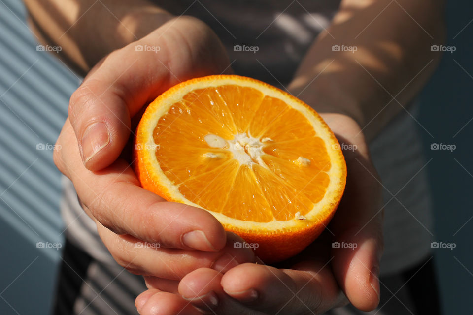 Hand holding an orange fruit