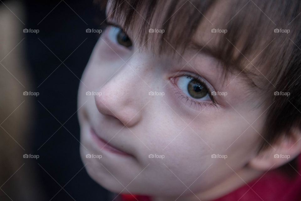 Close-up of a young boy looking up at the camera