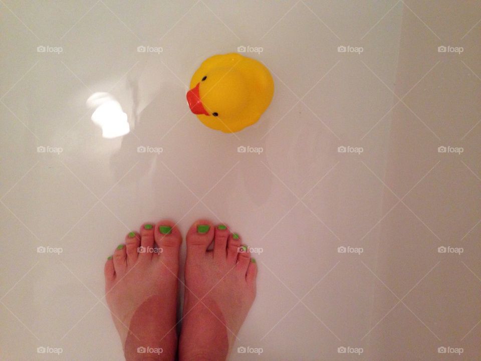 Feets with rubber duck in bath