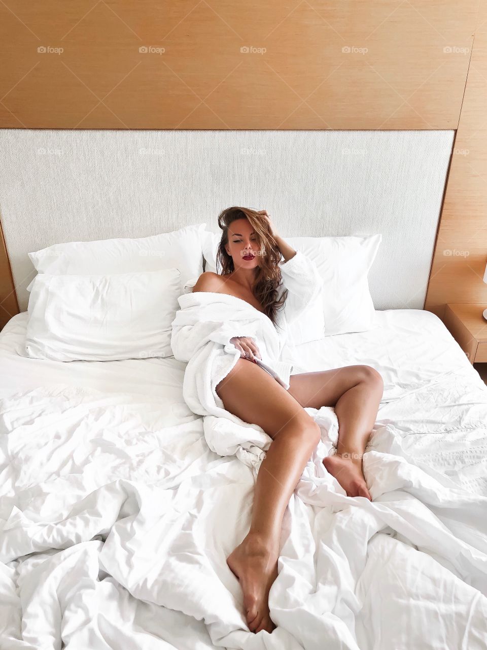 Beautiful sexy woman in bed. Luxury lifestyle. Red lips. Glamour and femme fatale. 