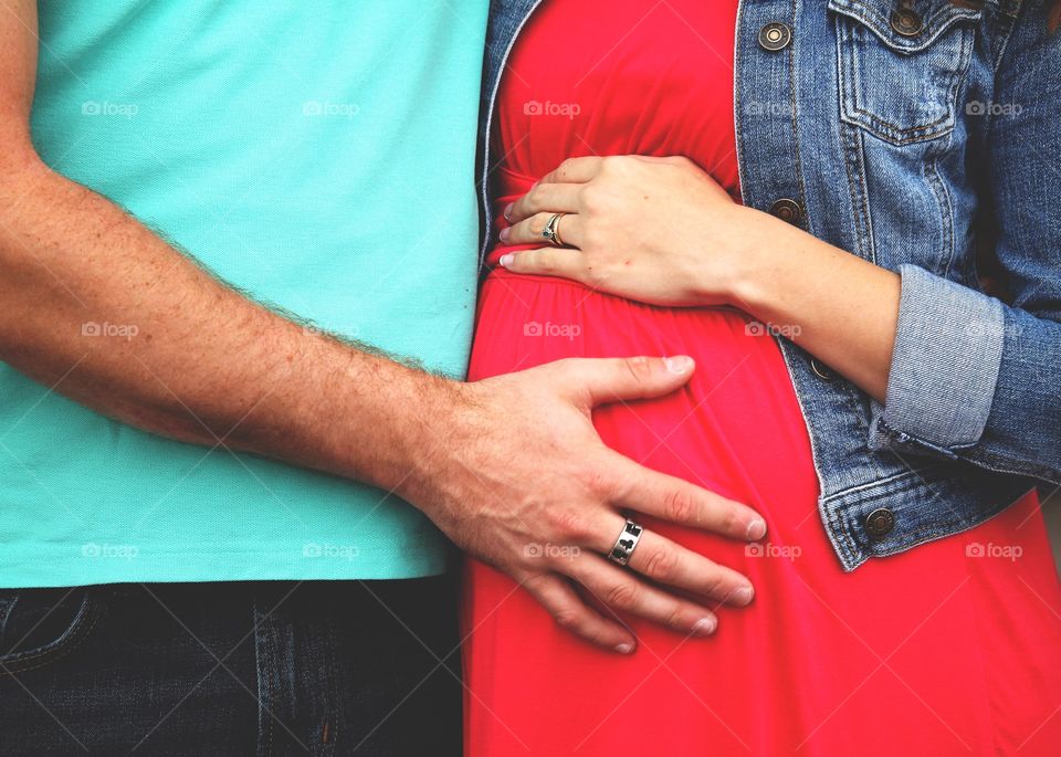 Mans hand on a pregnant womans belly