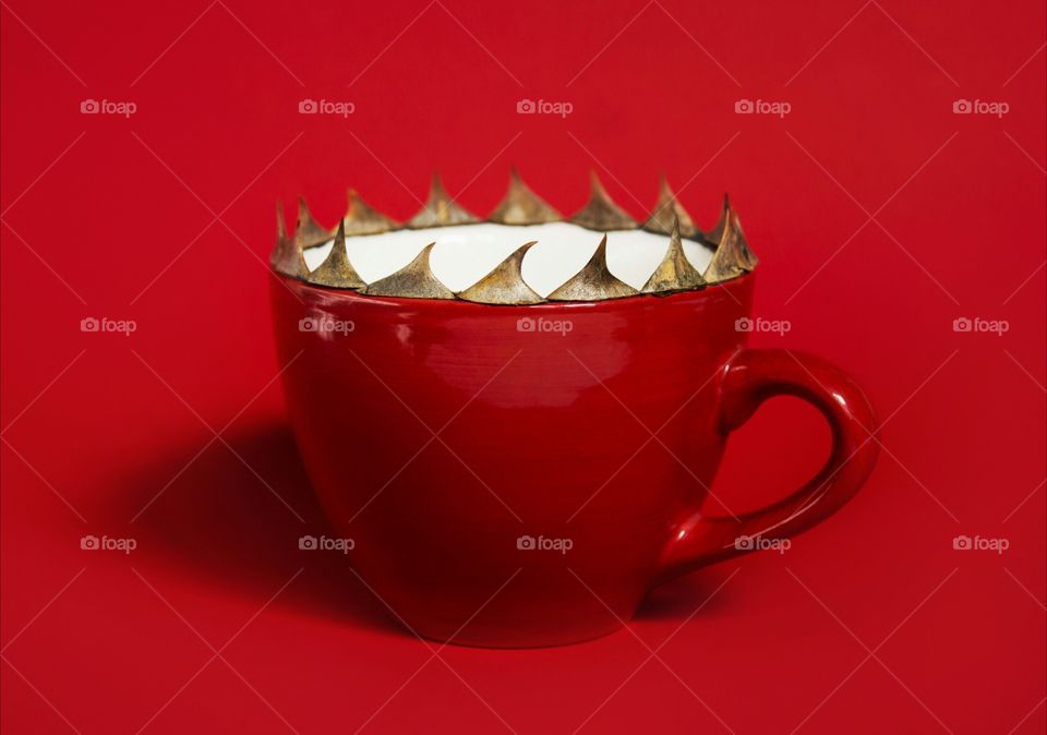 Red cup on red background, spikes on the edge