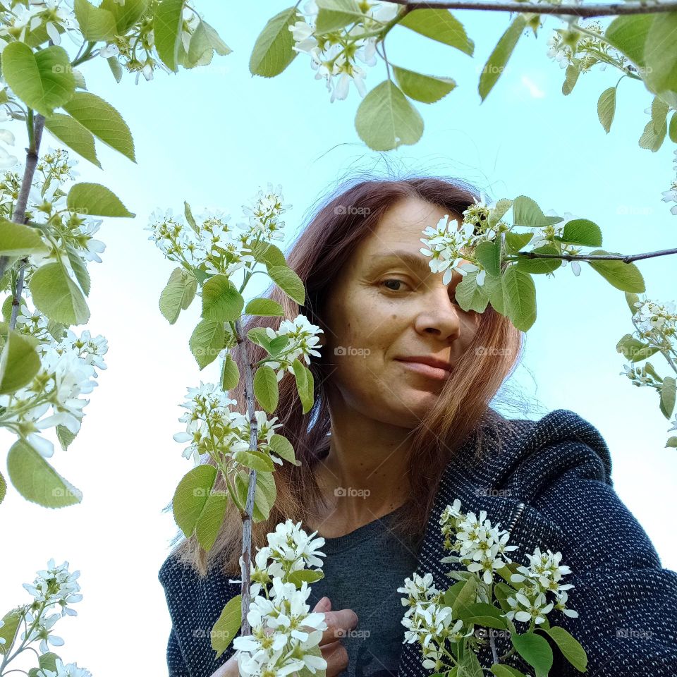 woman beautiful portrait with blooming tree white flowers, spring time