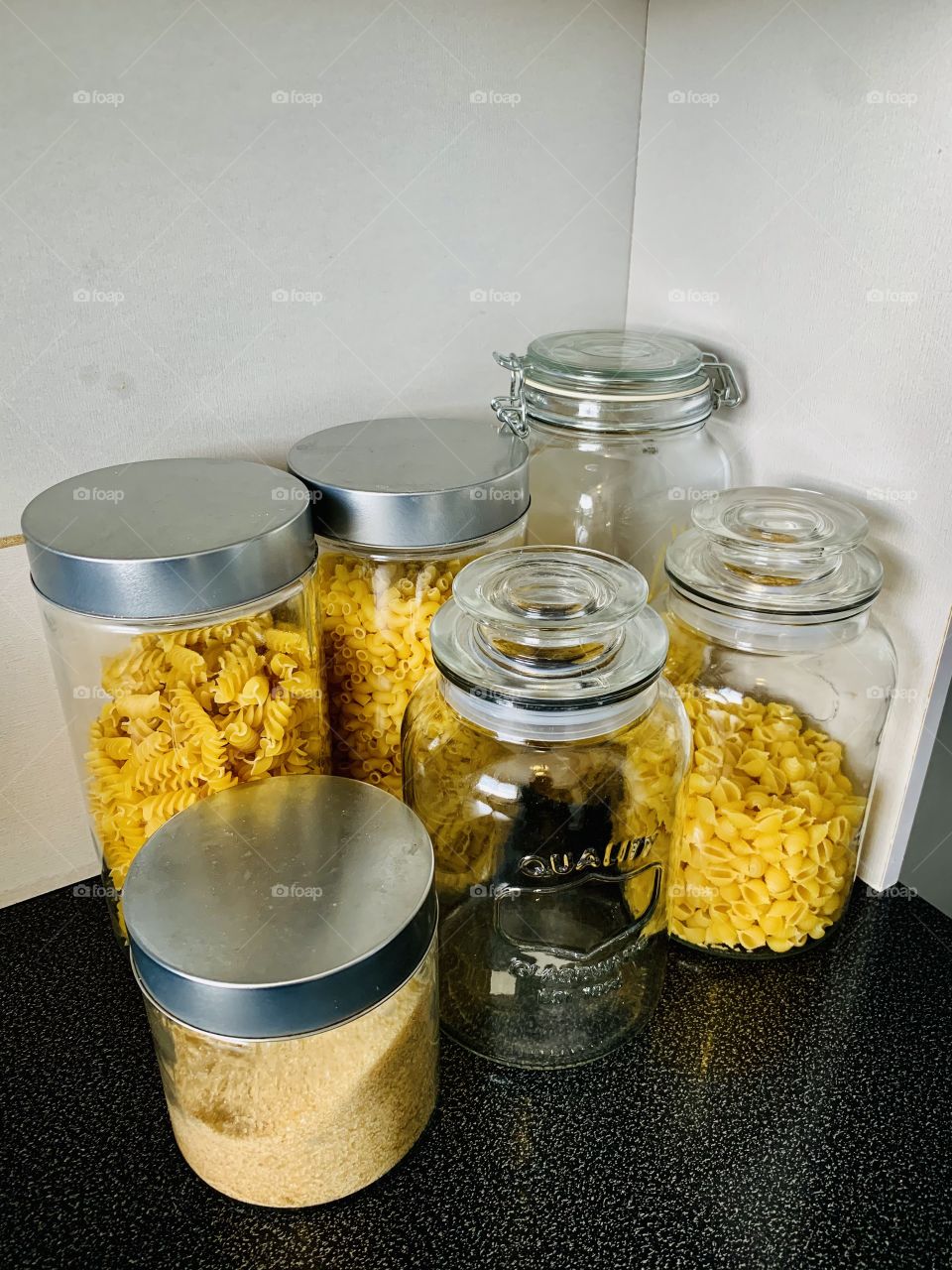 Various sized glass containers used as storage in the kitchen. Used for different dry food like sugar, oats, rice, pasta etc