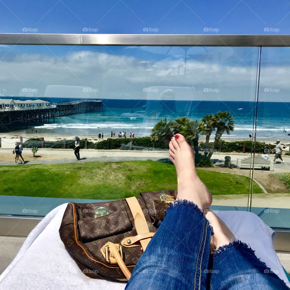 Relaxing on a balcony overlooking the ocean on a sunny day.