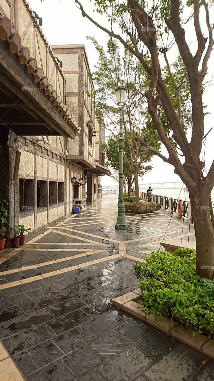a seaside park and restaurant, a seawall, accross far is bridge link tk Macau and Cotai City.