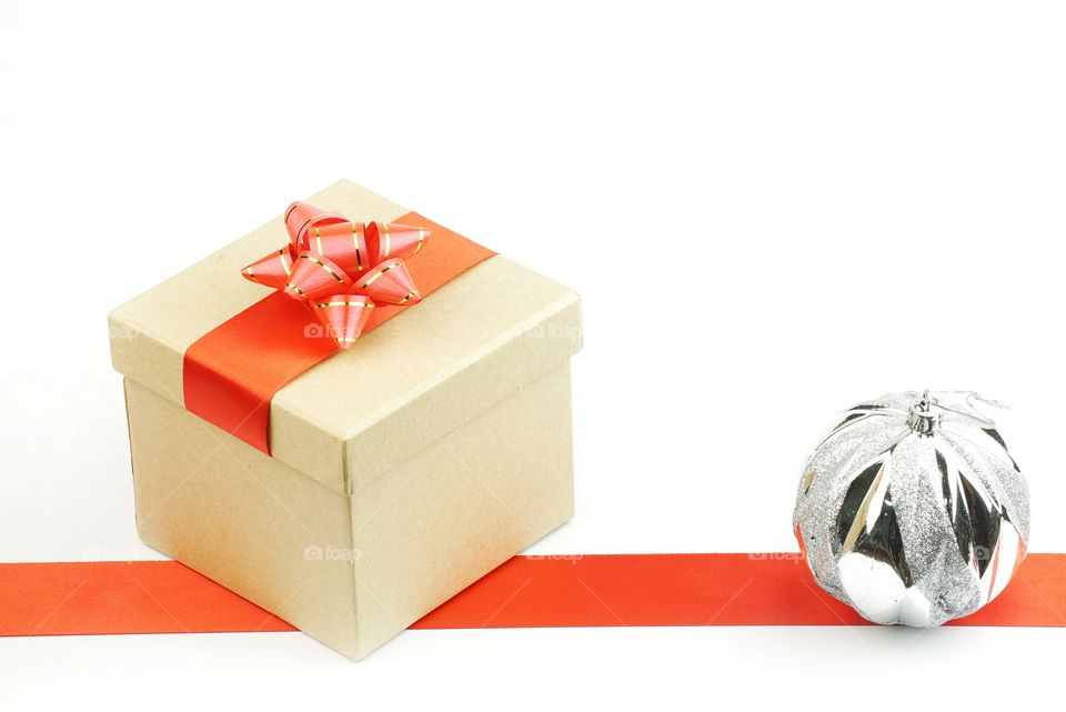 Christmas gift box with ornament and red ribbon stripe on white background