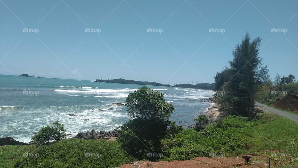 View of beautiful waves crashing onto the beach on a sunny day