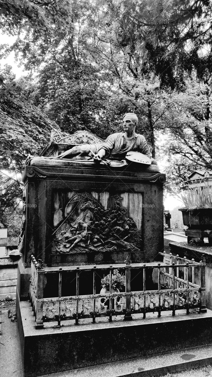 Black and white shot of the funerary bronze monument of the painter Théodore Géricault in Père Lachaise's graveyard in Paris