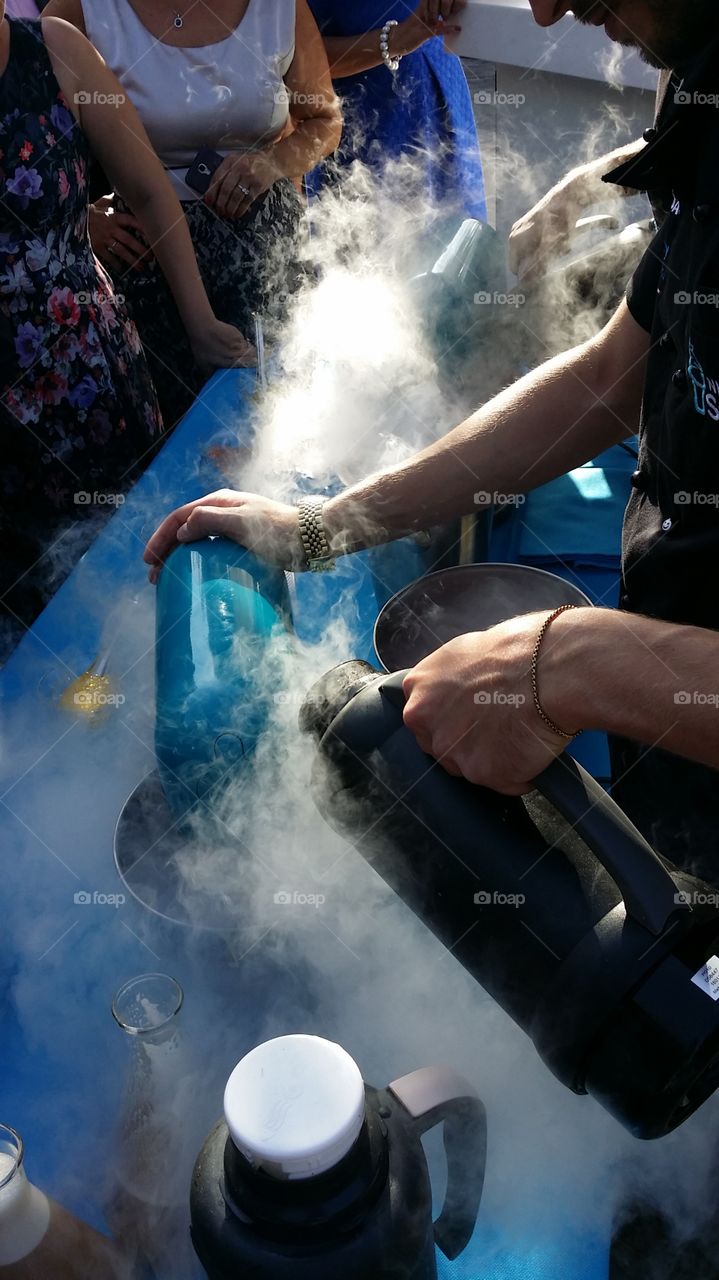 Hands preparing ice cream using liquid nitrogen and science